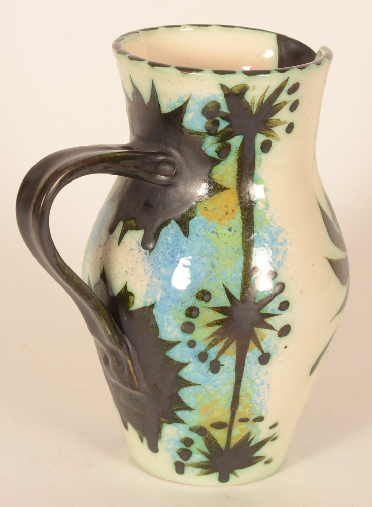 Celtic Pottery Newlyn phoenix pitcher — The black handle well balanced and backside decorated in black patterns painted over blues, greens and ochres