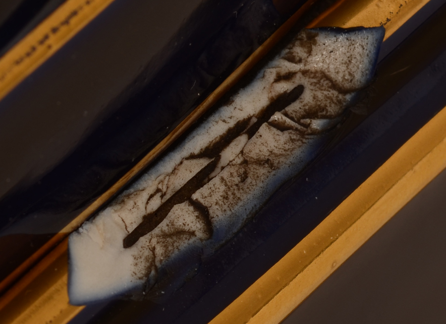 Asclepios vase — Detail close-up of the damage to the base, lenght 36 mm
