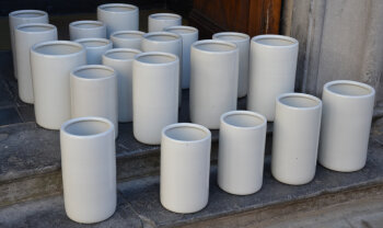 A large collection of white porcelain ice cream containers